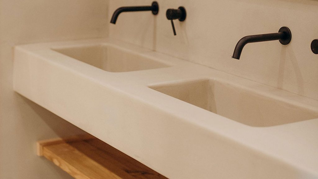 Bathroom walls finished with Terrazzo Granitech, featuring a sleek, patterned surface that contrasts with the more muted and matte look of traditional lime plaster